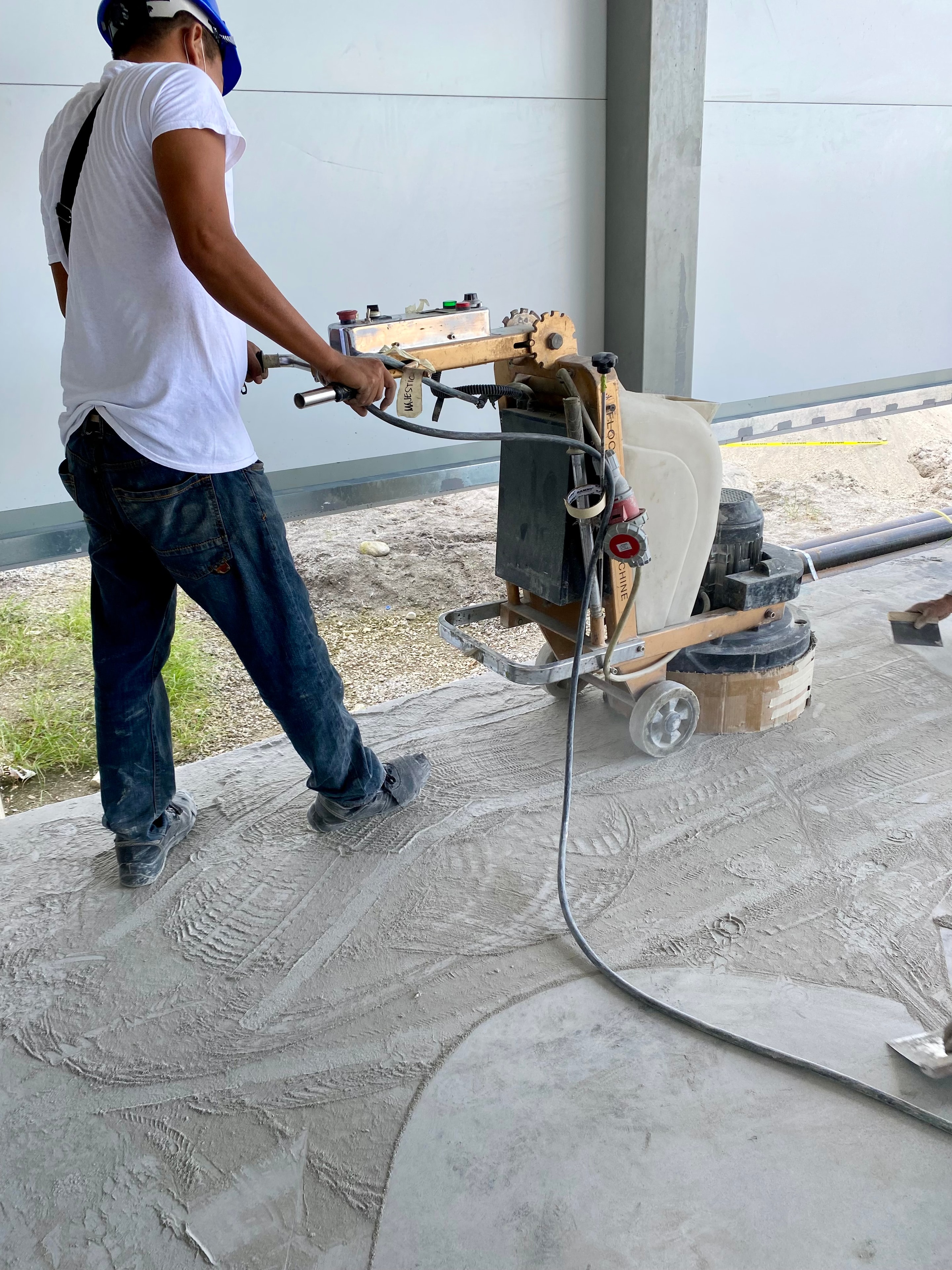 Worker using grinding machine to polish concrete floor